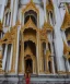 Placeholder: A woman stands in front of a grand palace, her eyes wide with wonder as she takes in the stunning architecture and ornate details.