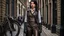 Placeholder: full-height portrait of a woman with straight shoulder-length black hair, with metal arms and legs, dressed in leather trousers, and a waistcoat, in a Victorian street next to a steampunk bike