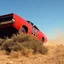 Placeholder: dramatic angle of dukes of hazard's general lee - 1969 red dodge charger with "01" on side jumping over a bush in a dusty field