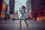 Placeholder: modern city a wide cross square a beautiful lady in nice pants and shirt pretty boots hip hop dancing city scape in background