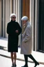 Placeholder: dos mujeres de 45 años caminando por una céntrica calle de una ciudad española, visten ropa de segunda mano, abrigo y jersey de cuello alto, es la moda y es tendencia, fotografía real, de cara a la cámara