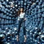 Placeholder: make a picture pretty stage made of metallic blue-gray teme 3d fractal recursive cubic and sphere base structures and a beautiful fashion model lady posing with cute,with chic look pairing well-fitted trousers with a sleek blouse,siver high heels ,makeup curvy long hair,dynamic camera zoom to full body and pan, dynamic lights.