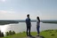 Placeholder: An image of two people exchanging criticism in a constructive and respectful manner, standing on a hill with a lake behind them 4K