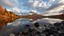 Placeholder: autumn reflections on a small lake, with the mountain in the background and rocks beneath dramatic clouds