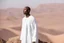 Placeholder: african man wearing white thobe. standing on high mountain looking out to the desert