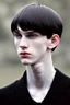 Placeholder: pale skin tone, black hair in a longish bowl cut with whisps in front of his ears, face is thin with high cheekbones and deep blue eyes that are often full of emotion and full lips. lean build that suggests he doesn't engage in a lot of physical activity. He is of average attractiveness with a boyish face.