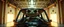 Placeholder: car driving happy 2d anime fluffy slimy alien sloth gremlin woman in the style of Escher and Giger and Fallout 4, pinhole cam, airbrush 3d rendering, on tv screen:A five-second cinematic single take in a clean industrial presentation hall.