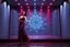 Placeholder: modern stage with gray-blue theme artistic decoration , color full dynamic lighting, a beautiful lady in modern maxy dark purple red dress with shining silver jwells dancing, 3D recursive fractal structure animating background