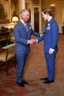 Placeholder: The Prince of Wales in traditional dress shakes hands with a young guest dressed in a blue suit, drawing room of St James's Palace, during a reception