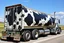 Placeholder: side view of a semitruck for fuel hauling, covered in large black cow spots, photo illustration