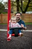 Placeholder: a 40 year old dad in the playground with his young 3 year old daughter playing on the swing but the dad is distracted by all the other kids curvy mums and loses control