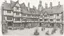 Placeholder: A Paved Courtyard, With Tudor Gothic Houses, Tall twisted Chimneys, twisted Roofs, People, Shops,