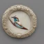 Placeholder: ivory brooch of a kingfisher, decorative design, classical ornament, highly ornate, highly intricate, highly detailed etching, marble carving, warm lighting, linen backdrop, sharp relief, dramatic lighting