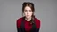 Placeholder: (Emily Rudd:0.15), beautiful face, pure face, face focus, facial, lips, looking at viewer, NSFW, simple background, plain gray background 1 girl, squatting brown hair, ponytail, school uniform, red cardigan, long sleeves, black skirt, black tights