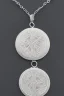 Placeholder: Silver necklace embossed Greek inscriptions in the shape of a circle containing small white crystals