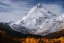 Placeholder: Portrait d’une montagne enneigé au bord d’un petit lac jaune en automne