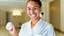 Placeholder: hotel housekeeping smiling holding small white earbuds