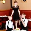 Placeholder: Russian guy young mommy boyish boylike short man's haircut men's face boyish features in black girlish lacy cocktail dress as mother in restaurant