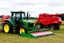 Placeholder: Parked at the edge of a field is a Claas brand Combine(Red) and a John Deere Tractor(Green) with a Vaderstad seeder