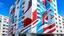 Placeholder: A large building is adorned with a mural that blends abstract art with architectural elements. The mural features a dynamic composition of geometric shapes in shades of white, gray, blue, and red, creating a three-dimensional effect that interacts with the building's structure. The artwork appears to extend beyond the flat surface, giving the illusion of depth and movement. The building itself is a multi-story structure with rows of windows and balconies, painted in neutral tones that contrast w