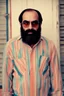 Placeholder: Man similar to demis roussos with glasses of colours and poor and short short short and poor hair on the head with receding hairline. Farsightedness glasses with big eyes. Shirt beard in the head. Vintage look and feel like photo style-of the 70s