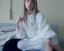 Placeholder: Billie Eilish, sitting on a chair, Black Short Dress, high detail, realistic, 8k