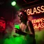Placeholder: An "EMPTY GLASS" performing at dance club, his name is "EMPTY GLASS" and looks crazy, and green slime on stage, Neon lights and smog, "EMPTY GLASS" SIGN ON WALL