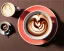 Placeholder: Cappuccino art microfoam in mug saucer, plaid