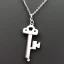 Placeholder: Clear polyester necklace with a chunky silver pendant in the shape of a key