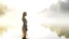 Placeholder: A serene summer haven at dawn: A blonde Caucasian woman in a white sundress stands by a tranquil lake, mist rising, sun barely visible.