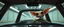 Placeholder: car driving happy 2d insect anime fluffy slimy alien sloth gremlin man in the style of Escher and Giger and Fallout 4, pinhole cam, airbrush 3d rendering, on tv screen:A five-second cinematic single take in a clean industrial presentation hall.