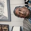 Placeholder: A highly detailed portrait black and white photograph captures an American Indian elder tribal leader in a hyperrealistic manner. The chief wears striking blue-on-red tribal panther makeup, facing forward with a strong gaze. The intricate texture of his skin and his intense expression are emphasized. Shot with a 50mm f2 lens on a GFX100 camera, the image features dramatic front lighting, creating a distinctive look. Aspect ratio: 2:3. Quality: 2.