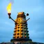 Placeholder: statue of a Dalek on Statin Island, with a torch