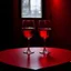 Placeholder: a table showing two wine glasses in a dark room, red hues