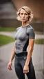 Placeholder: photography of a beautiful anorexic woman, grey satin triathlon top, sports illustrated, blond short wavy bob haircut, pronounced sternum, anthracite running leggins