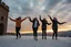 Placeholder: a group of Turkish young ladys in sports pants and blouse winter jacket are dancing in Babak Castle in Iran west north ,cloudy sun set sky,snowy environment