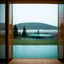 Placeholder: A polaroid photo of an odd room with structures. A transparent tarpaulin covers an image. There is a group of fir trees in the background and a high hill in the distance. A lake. The surface below is in a pastel color. Fog is present.