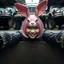 Placeholder: Closeup Goth Asian woman smiling, lying pose, rabbit mask, pink short hair, latex suit, ragged clothes, fullbody, dieselpunk, valves and old cars behind, the perspective looking up from the bottom of an empty well , 8k,macro photography,