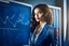 Placeholder: A pretty brown-haired, light-skinned woman in an elegant blue suit stands in a classroom in front of a blackboard with various charts and diagrams, in the sunlight