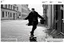 Placeholder: a black and white photo of a man on a skateboard, iphone video, swedish urban landscape, clippings of a fashion magazine, passages, detective coat, dirt and grawel in air, featured on dribble, damage class, official screenshot, european buildings, gestures, guide