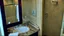 Placeholder: hotel bathroom with. hole in the wall spraying water all over with broken mirror and sink