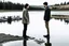 Placeholder: An image of two people exchanging criticism in a constructive and respectful manner, standing on the ground with a lake behind them