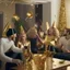 Placeholder: A picture of partying people in a living room with gold party decoration