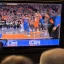 Placeholder: a man watching the New York Knicks game on a television