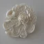 Placeholder: ivory brooch of a rose, opalescent marble carving, decorative design, classical ornament, highly ornate, highly intricate, highly detailed etching, marble carving, warm lighting, linen backdrop