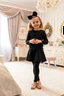 Placeholder: a 6 years old girl in modern clothing and makeup standing pose with cute and joy with pertty shoes in a very large luxury baby bedroom