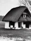 Placeholder:  a small ukrainian white house with a thatched roof in a big dark wide field Christmas carols with a Christmas star in the style of old photos