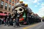 Placeholder: cartoonish jesus parade balloon pulled by multiple grim reapers, multi colored, bright, vivid, psychedelic, high detailed, high gloss, insanely detailed, matte, horrorcore, lining the street, unsettling contrast, monument to death, live action shot grim reaper parade, pulling a jesus parade float