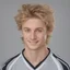 Placeholder: 85mm DSLR color photography of a very detailed headshot fitting all of head and hair in frame. 22-year-old Germen soccer player, with blonde hair color and no facial hair and with a small smile, grey background