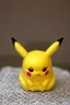 Placeholder: cute and nice faced marzipan Pikachu on a lace blanket on a kitchen table